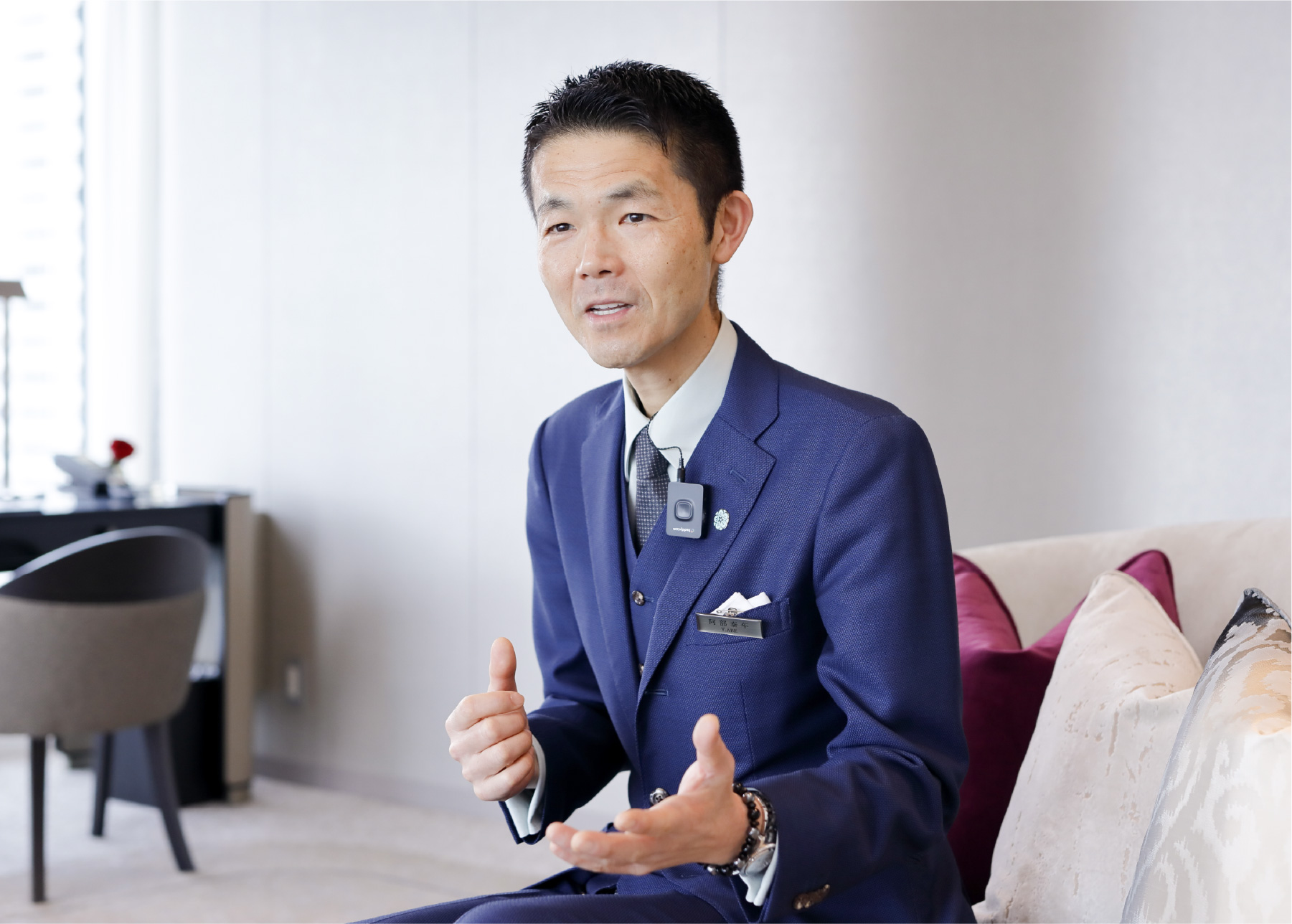 「ザ・カハラ・ホテル&リゾート 横浜」総支配人・阿部 泰年が手振りを交えながら話している様子