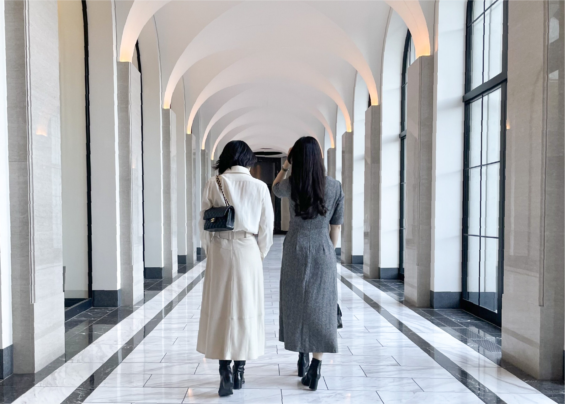 ホテルの廊下を並んで歩く2人の女性