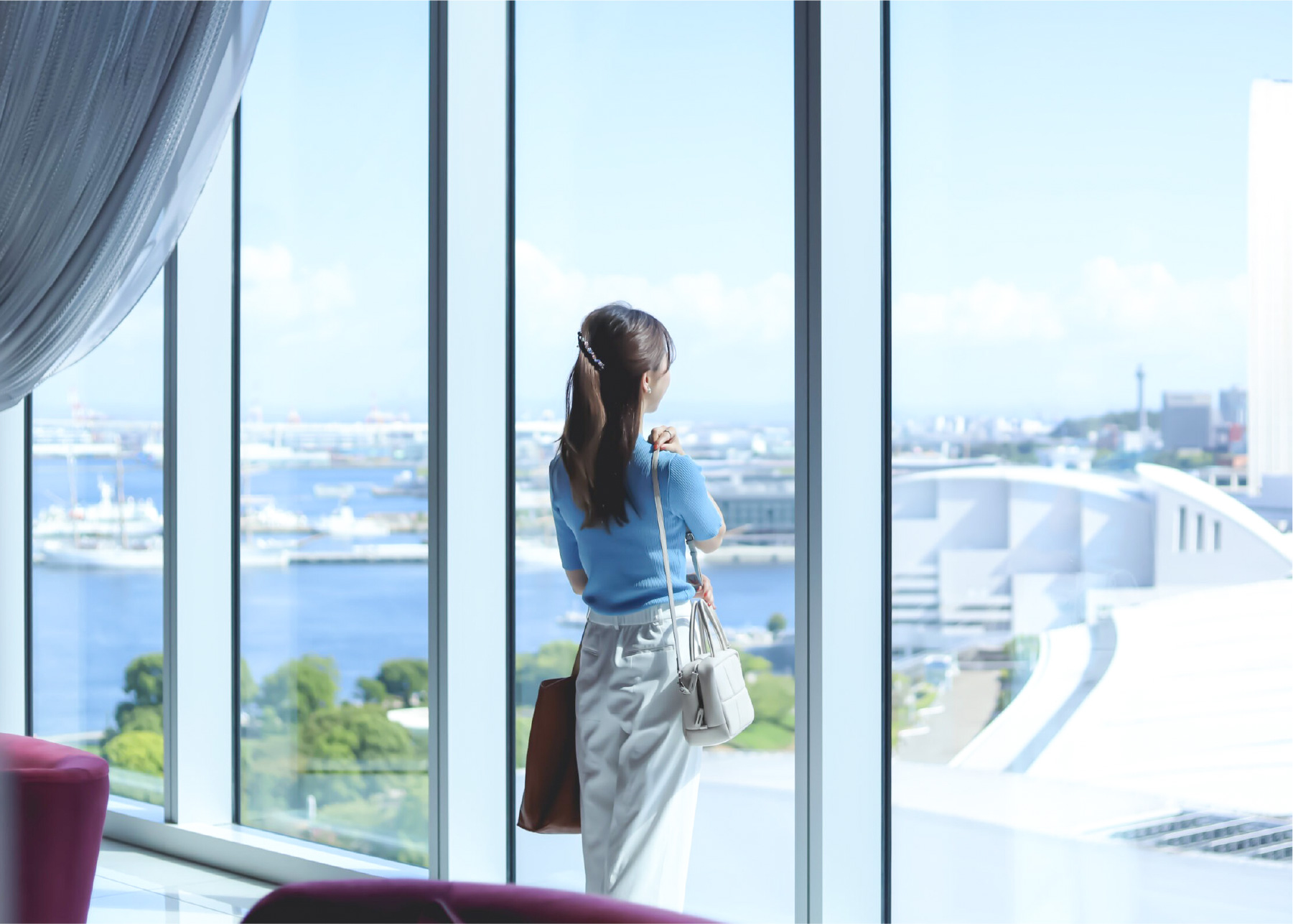 窓際で外を見つめる女性